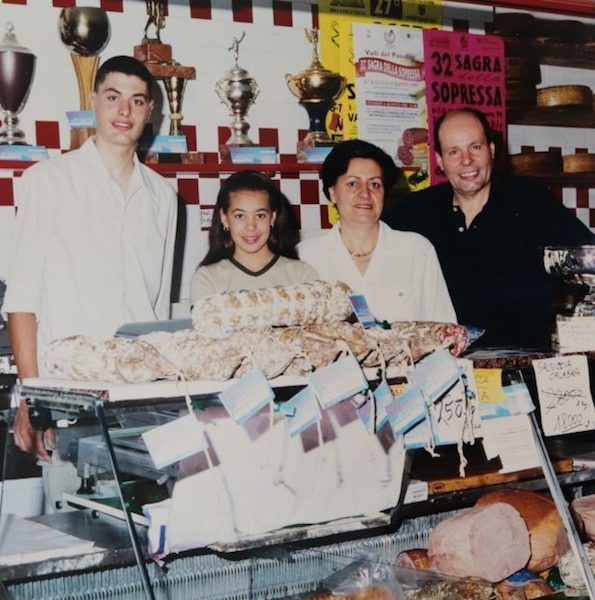 Famiglia Aste davanti al bancone dei salumi